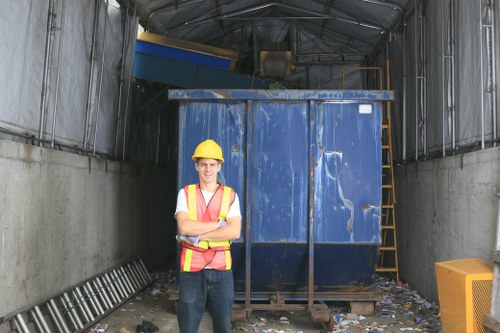 Team member checking accessibility features on a device while standing beside a branded skip in Hillingdon